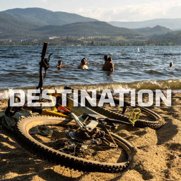 mountain bike on a beach with people swimming in the background