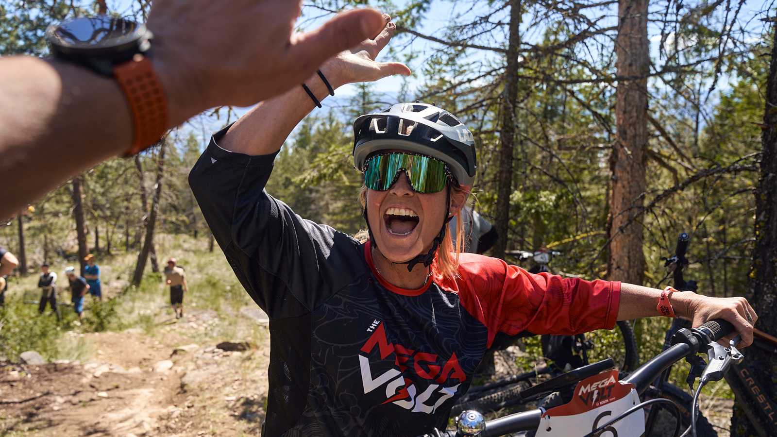 2 mountain bikers giving each other a high five on the trail